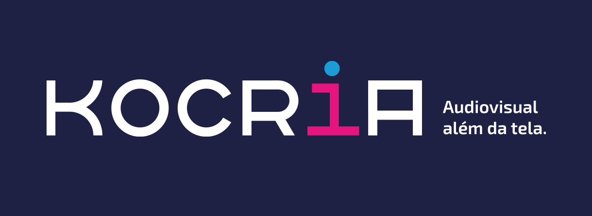 Logo da Kocria, escrito em fonte branca sobre um fundo azul escuro, a letra “i” está em fonte rosa com azul. Ao lado, o texto: Audiovisual além da tela.